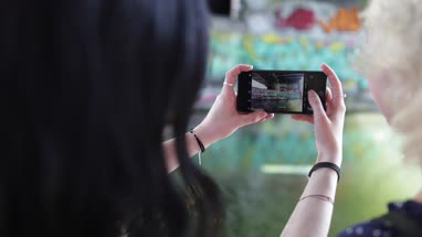 POV female friends taking photo of graffiti street art
