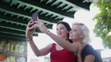 Female friends taking selfie in urban city