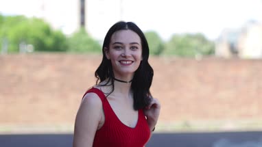 Portrait of young adult female turning to look at camera on street