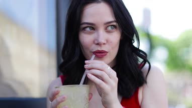 Young adult female having a cool drink outdoors in summer