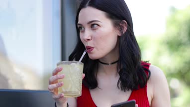 Young adult female checking smartphone whilst out with friends
