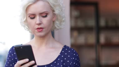 Young adult female checking smartphone in bar