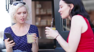 Female friends enjoying a refreshing drink outdoors in summer