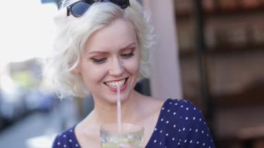 Young adult female having a cool drink outdoors in summer