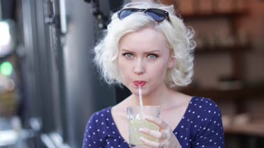 Young adult female having a cool drink outdoors in summer