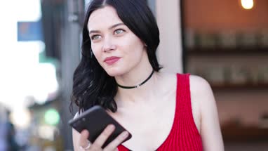 Young adult female checking smartphone in bar