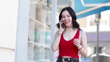 Young adult female walking down street whilst on smartphone