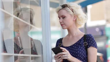 Young adult female using a smartphone whilst shopping