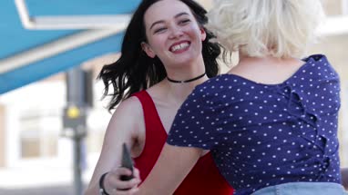 Female friends meeting outdoors on shopping street