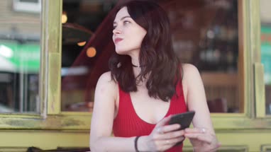 Young adult female checking smartphone in bar