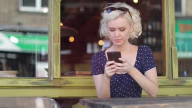 Young adult female using smartphone in bar