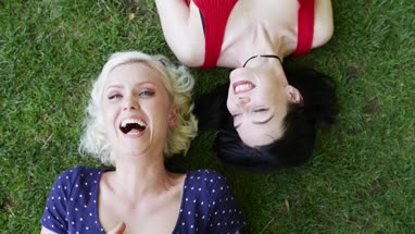 Overhead shot of female friends sunbathing in park