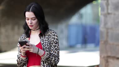 Young adult female using smartphone on street