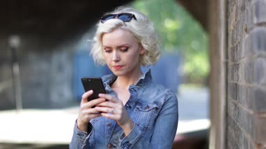 Young adult female using smartphone on street