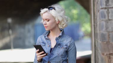 Young adult female using smartphone on street