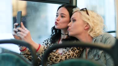 Female friends taking a selfie on a London bus
