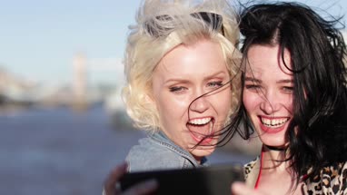 Tourists taking a selfie with Tower Bridge in the background