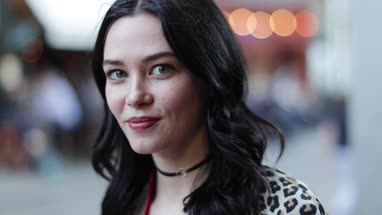 Portrait of young adult female turning to look at camera on street