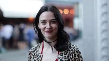 Portrait of young adult female turning to look at camera on street