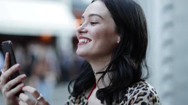 Young adult female on a video call with friend outdoors