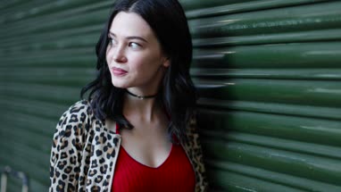 Young adult female waiting for friend on urban street