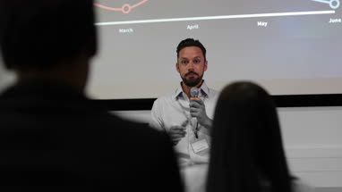 Speaker at a business training conference taking a question