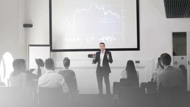Speaker at a business training conference listening to a question