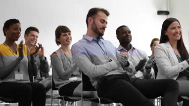 Audience at a conference applauding speaker