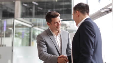 Businessmen shaking hands in a corporate office