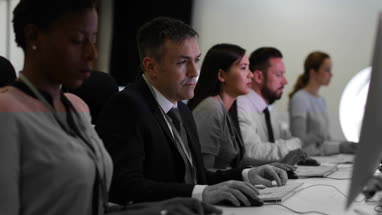 Businessman using computer in crowded office