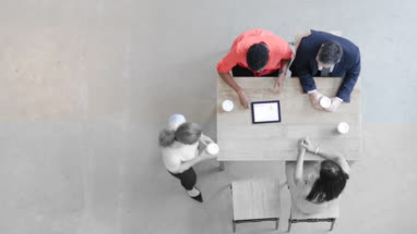Overhead shot of a team using a digital tablet in a business meeting