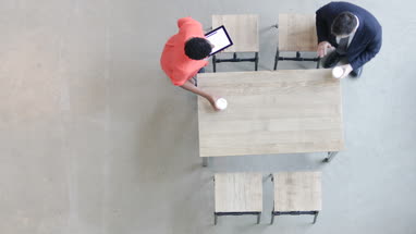 Overhead shot of a colleagues using a digital tablet in a business meeting
