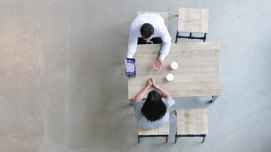 Overhead shot of a colleagues using a digital tablet in a business meeting