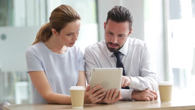 Colleagues using a digital tablet in a meeting