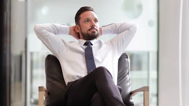 Successful businessman leaning back in chair 
