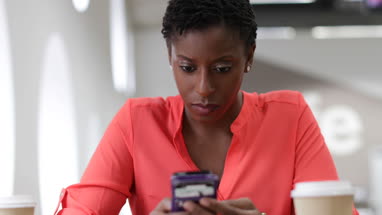 Employee on coffee break using her smartphone