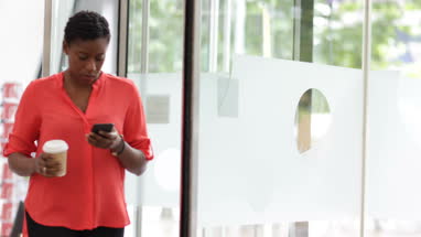 Employee arriving at office using her smartphone