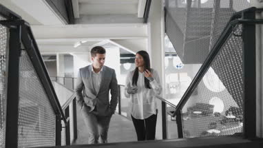 Colleagues walking up staircase in an office talking