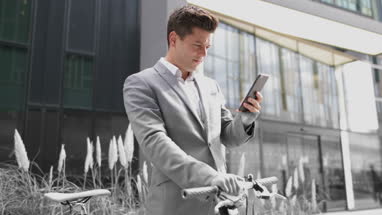Businessman with bicycle and smartphone