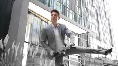 Businessman cycling to work using smartphone