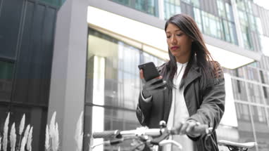 Businesswoman with bicycle and smartphone