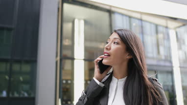 Businesswoman on smartphone waiting for taxi cab