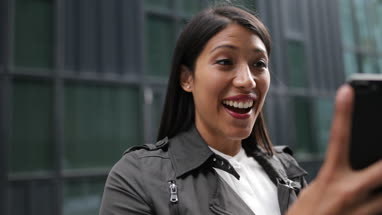 Smiling woman on video call outdoors