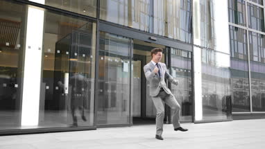 Businessman leaving work doing a heal click jump