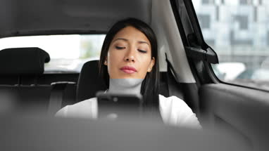 Businesswoman looking out of window of taxi cab