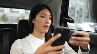 Businesswoman paying via app for taxi cab ride