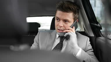 Businessman in taxi cab using smartphone