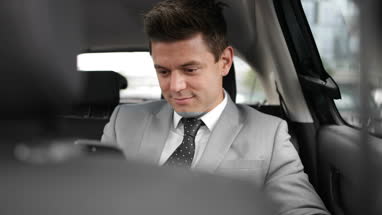Businessman looking out of window of taxi cab
