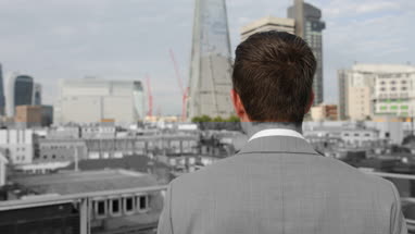 Businessman looking out at London city skyline