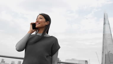 Businesswoman using smartphone with skyscraper in background
